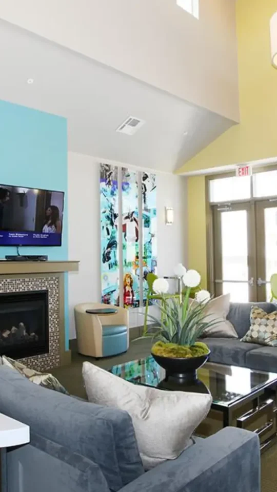 a living room with blue walls and a fireplace at The Outlook Ridge Apartments