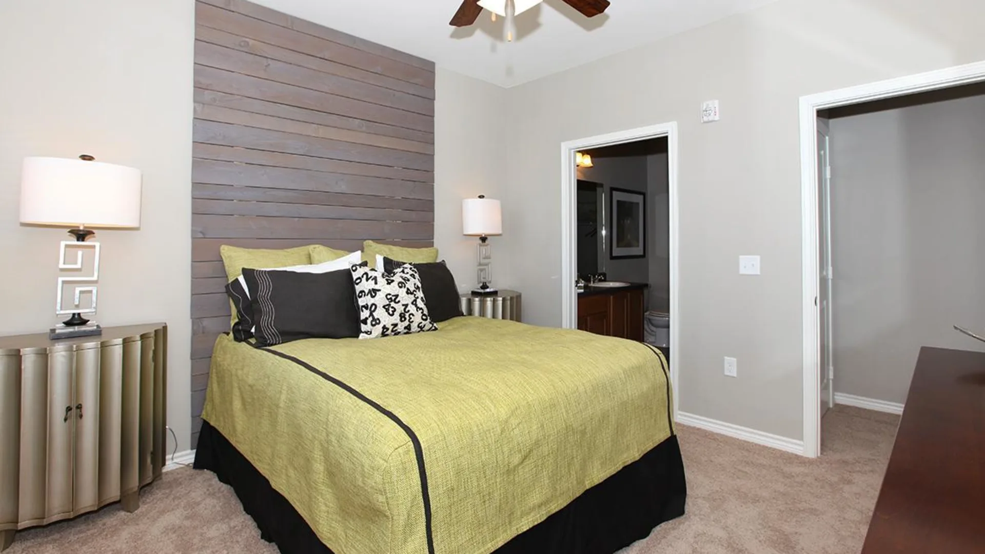 a bedroom with a bed, nightstand, and lamp at The Outlook Ridge Apartments
