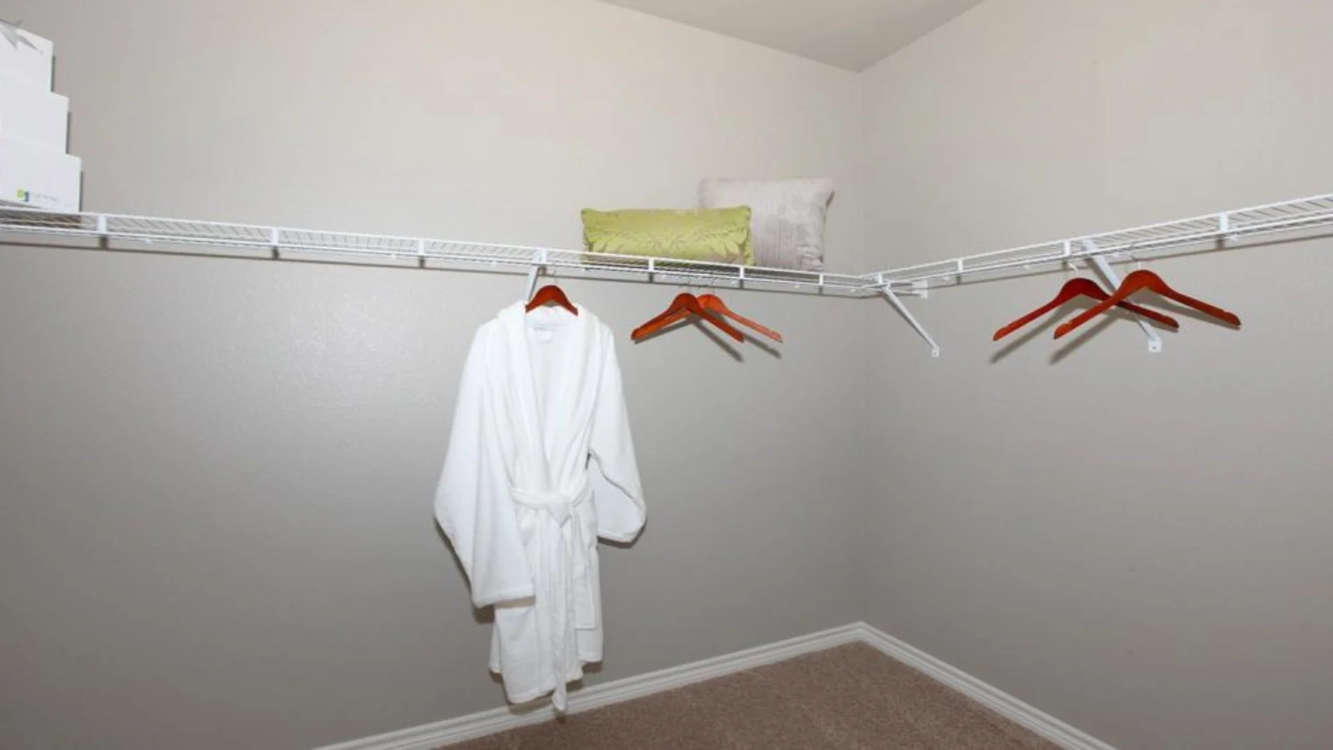 a closet with a robe and towels hanging on the rack at The Outlook Ridge Apartments