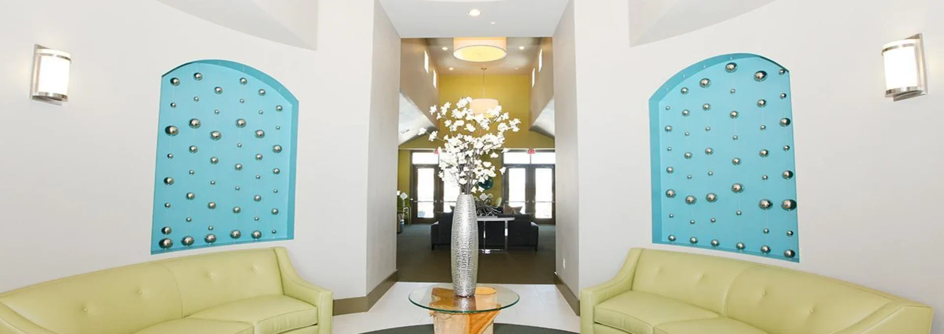 a lobby with a green couch and blue chairs at The Outlook Ridge Apartments