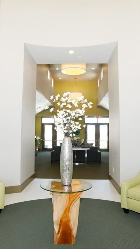 a lobby with a green couch and blue chairs at The Outlook Ridge Apartments