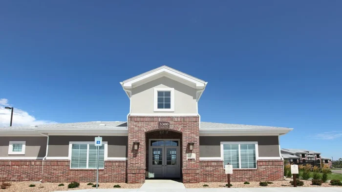 the front of a building with a driveway and a sign that says welcome at The Outlook Ridge Apartments
