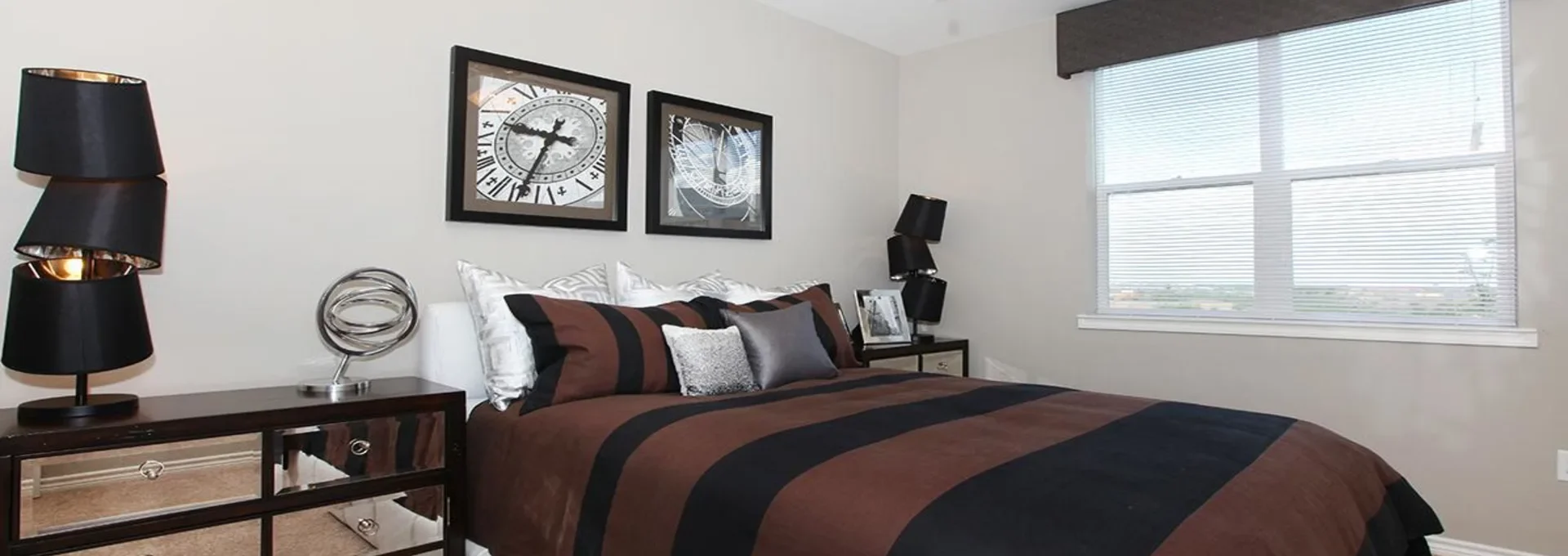 a bedroom with a black and brown bedspread and ceiling fan at The Outlook Ridge Apartments