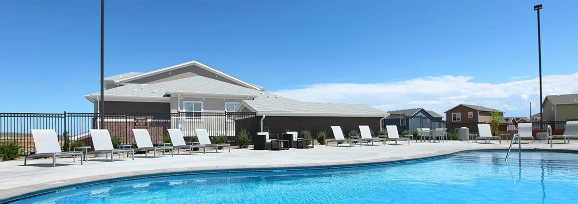 a pool with lounge chairs and a patio at The Outlook Ridge Apartments