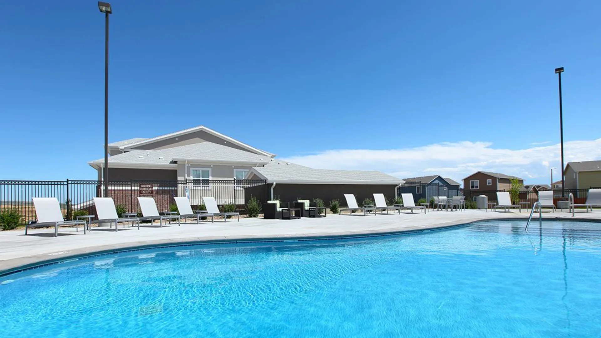 a pool with lounge chairs and a patio at The Outlook Ridge Apartments