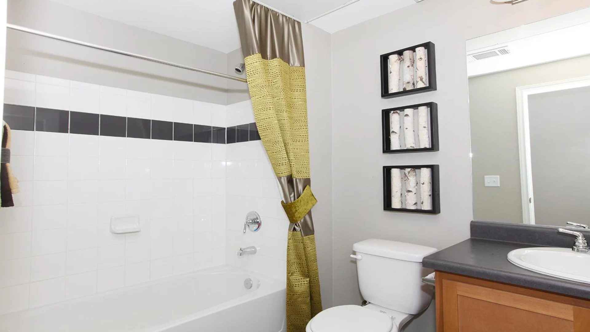 a bathroom with a shower curtain, toilet, sink and tub at The Outlook Ridge Apartments